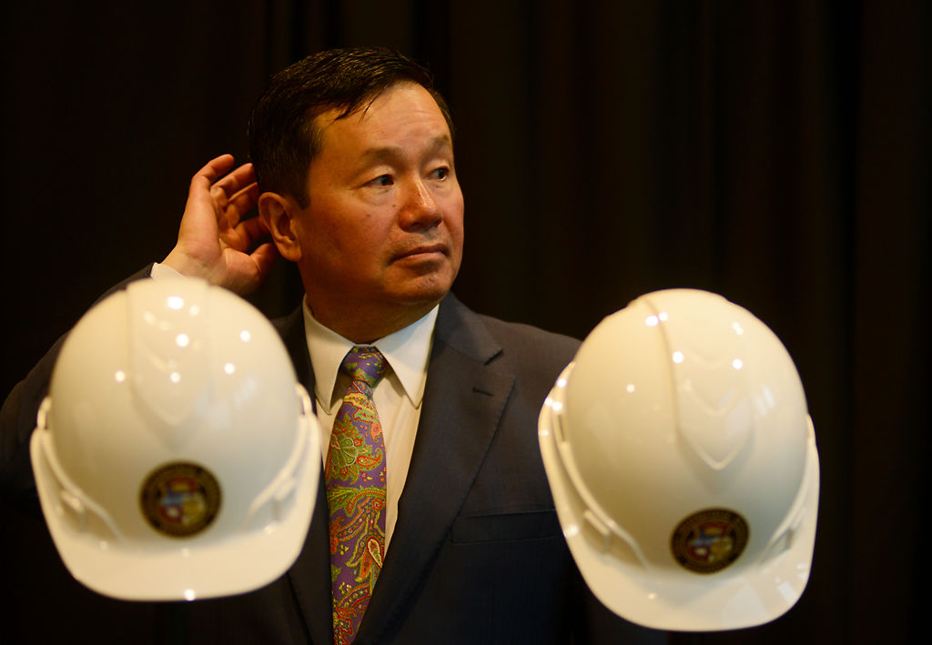 MU System President Mun Choi waits behind the ceremonial hard hats and gold shovels